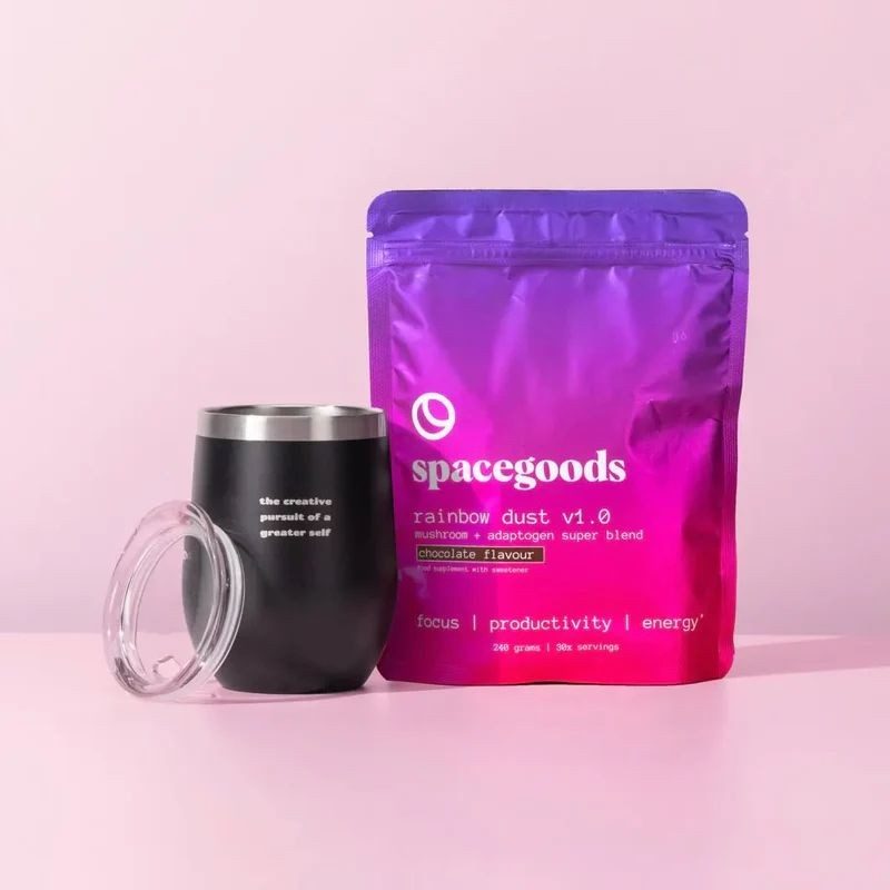 A pouch of Spacegoods Rainbow Dust mushroom coffee blend next to an insulated travel cup